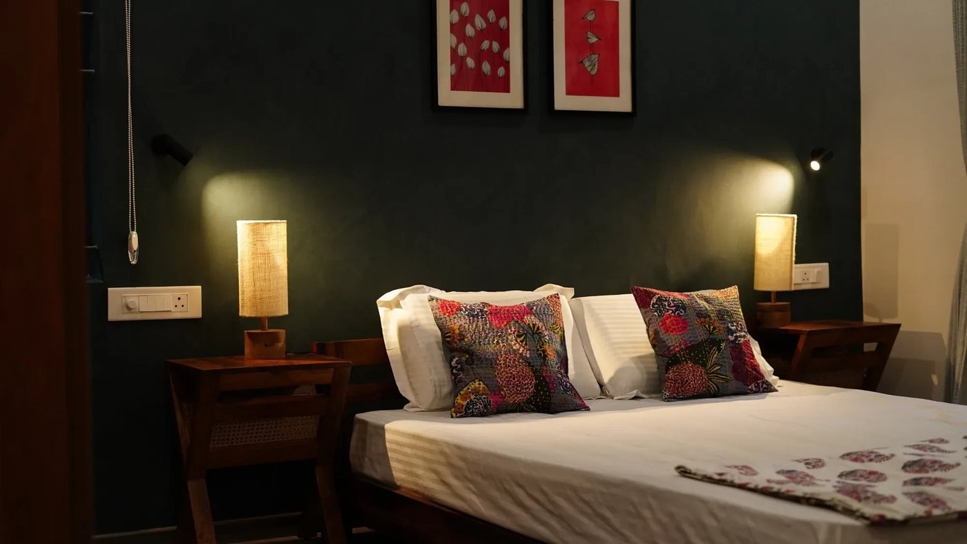 Bedroom with a deep-teal wall and bedside lamps