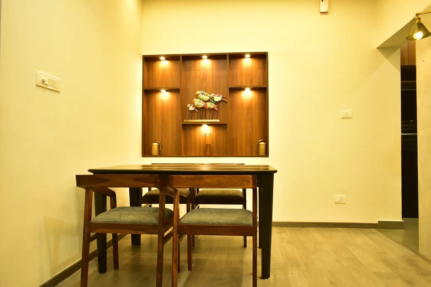 Dining table under a lit wooden niche