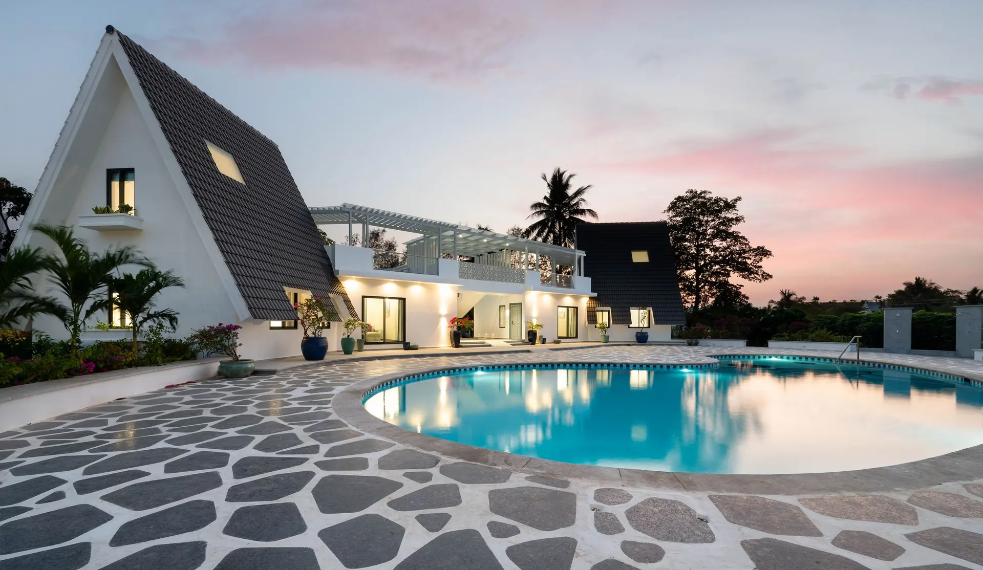 Pool and A-frame cottages at Ritam wedding venue at dusk