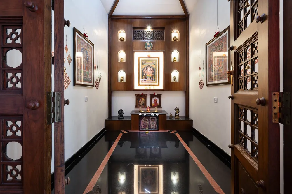 Finished pooja room with carved wooden doors